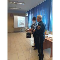 Komendant Straży Miejskiej i pani Wanda Grabowska oglądają prezentację starych zdjęć Straży Miejskiej