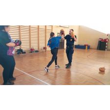 Funkcjonariusz uczy dwie kobiety stosowania uderzeń